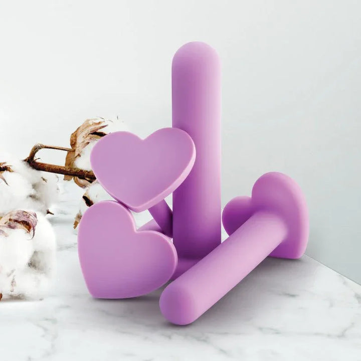 Lilac Wellness dilators propped against a wall with cotton bolls on marble