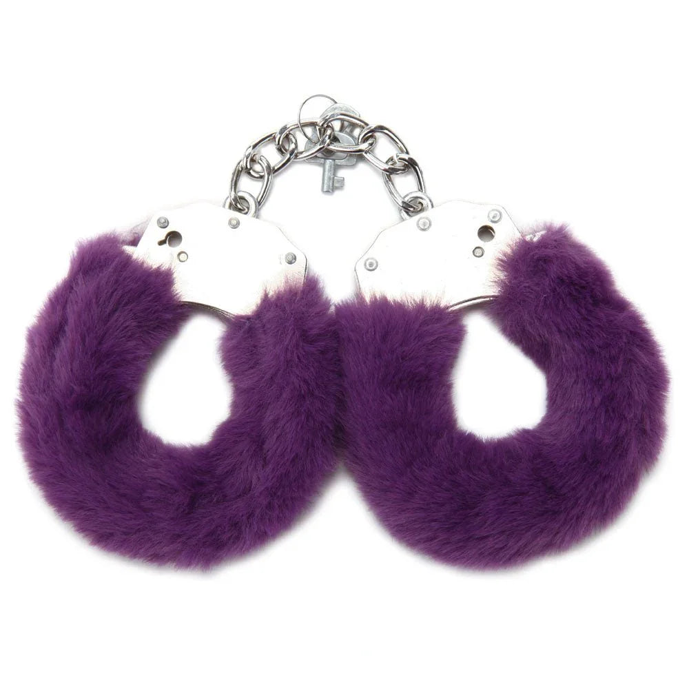 Purple furry handcuffs alone on white, chrome cuffs with a key on the chain