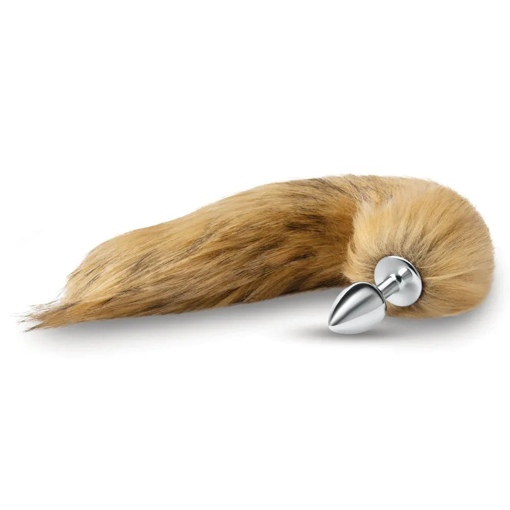 Brown fox tail butt plug lying on white, polished metal plug at the base of the tail