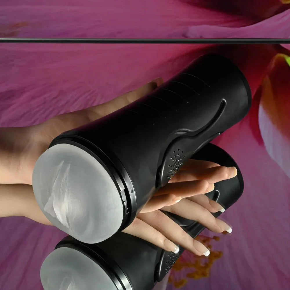 Hold Tight stroker held in a hand on a pink floral backdrop