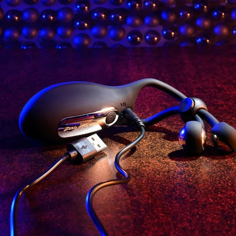 The Big Bang with its USB charging cable attached on a dark surface