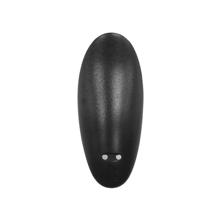 The wireless remote seen from above, showing its charging pins