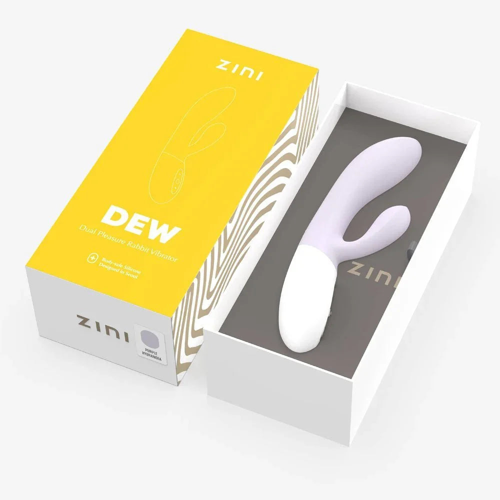 Zini Dew seated in its opened gift box beside the yellow lid